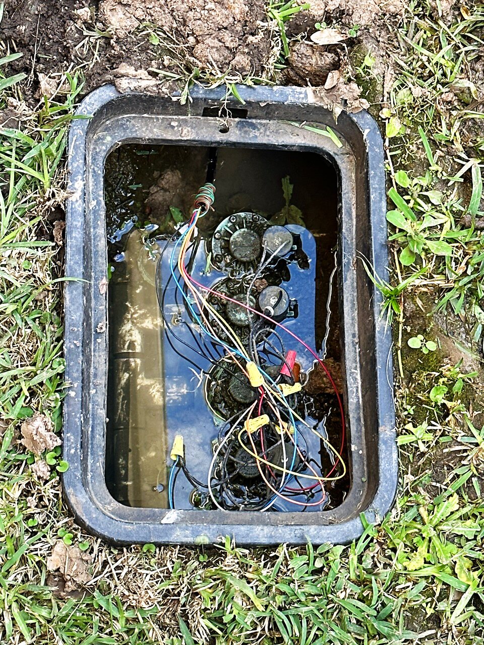 An open irrigation valve box inspected during an Elite Sprinkler system evaluation in Katy