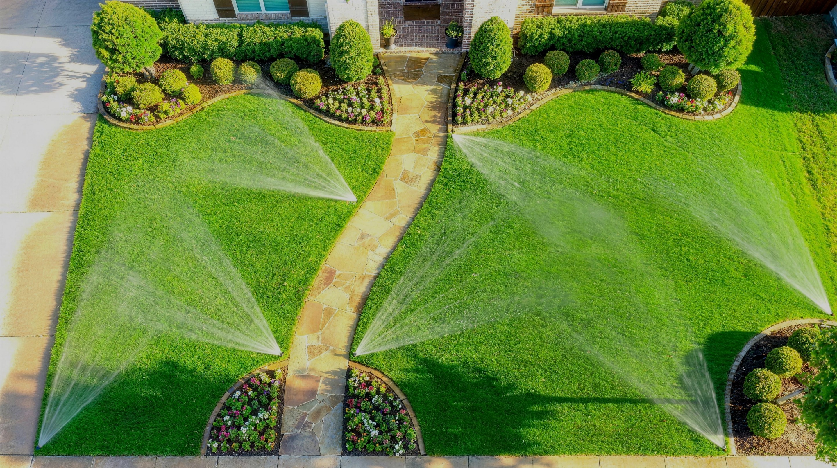A lawn sprinkler throwing a glittering crown of sparkling water droplets in golden light