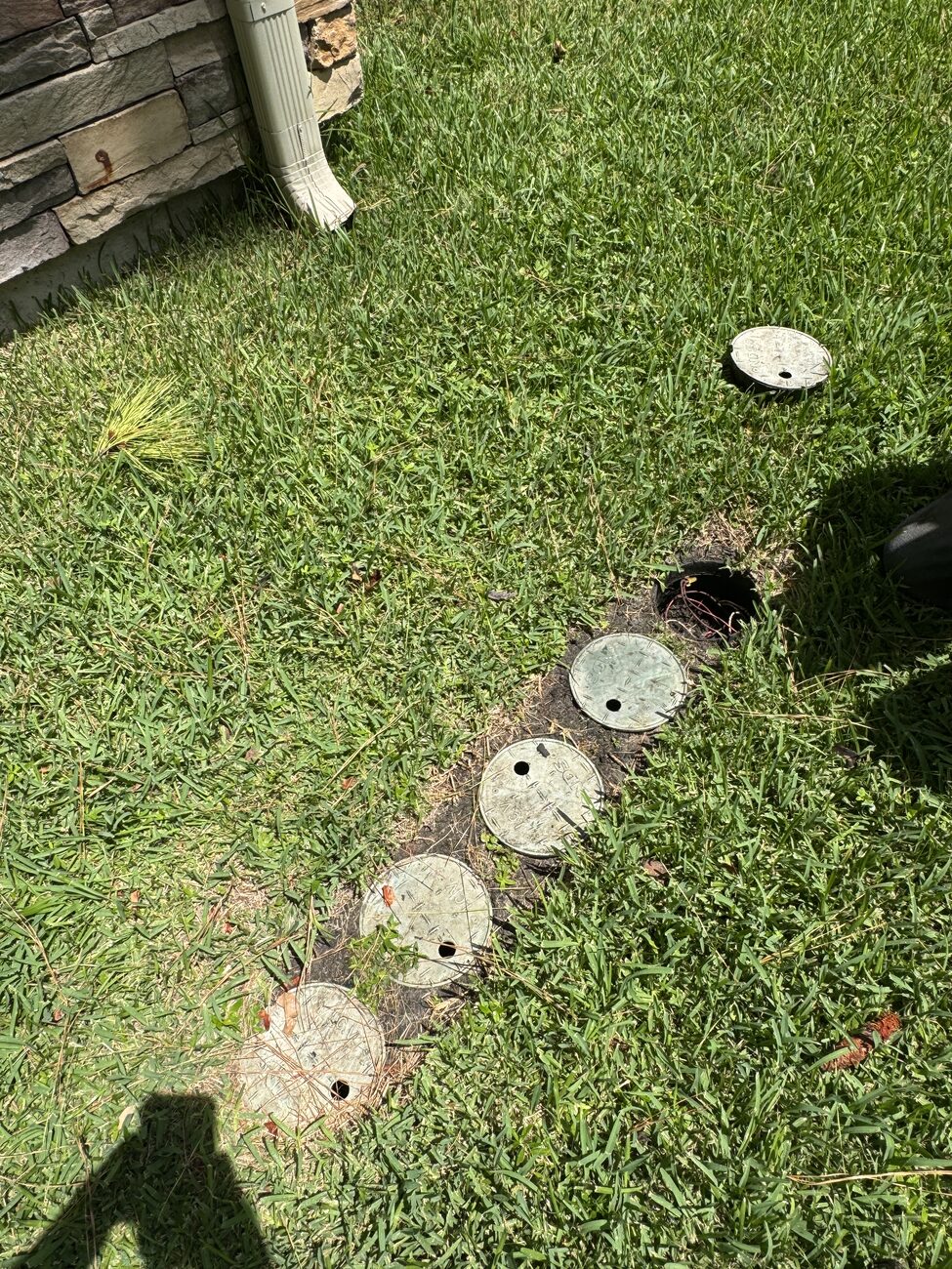 Valve boxes set flush in a healthy Katy lawn