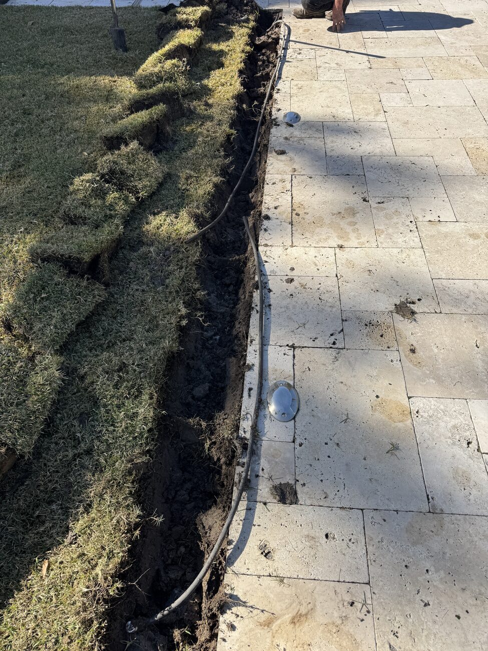 A clean irrigation install along a paver walkway