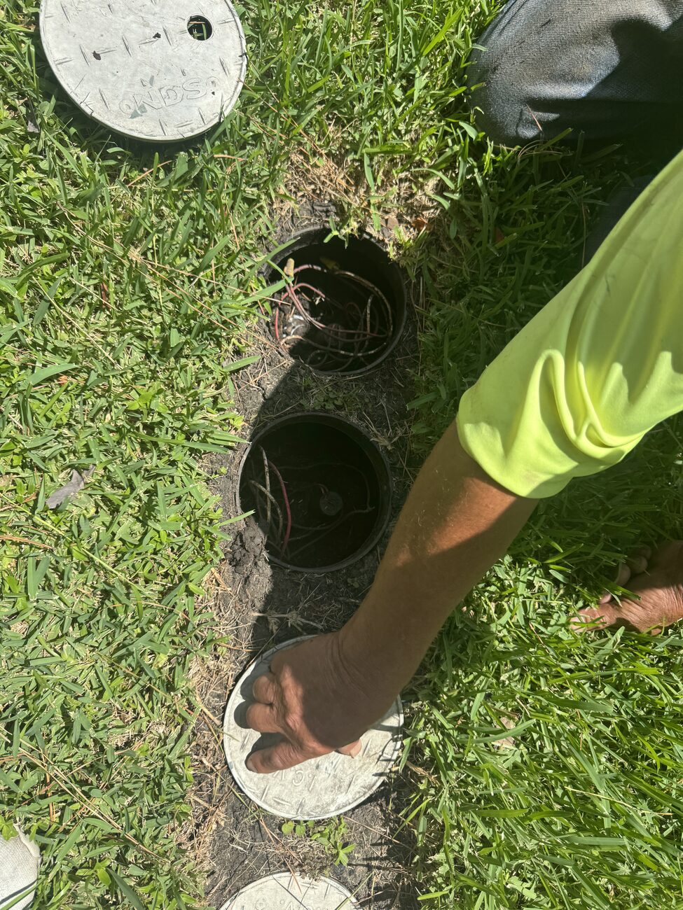Elite technician setting valve boxes in a Katy lawn